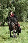 Frau reitet Friese / woman rides friesian horse